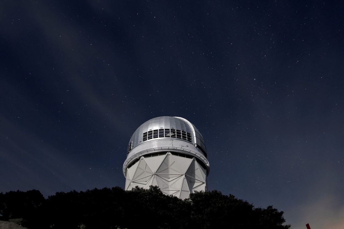 telescope pointed at a star-filled night sky